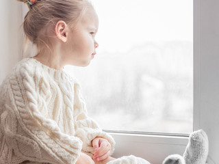 A little girl in the white knitted sweater - 167429333