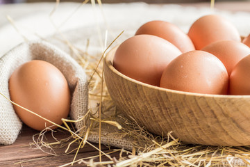 Chicken eggs in a basket with hay
