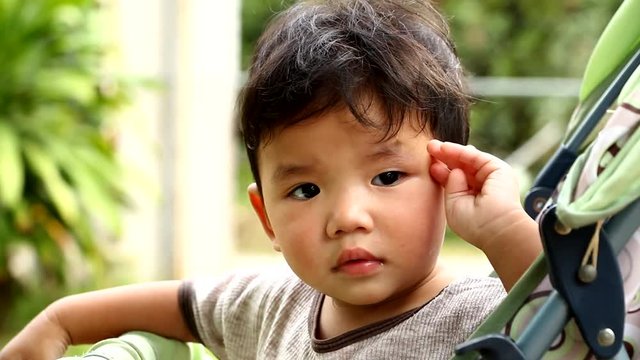 Thai  baby  playing  in a stroller