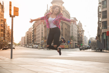 Hilarious young woman jumping on sidewalk