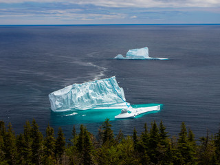 Two icebergs near a shore seen from high angle in St. John's, Newfoundland, Canada