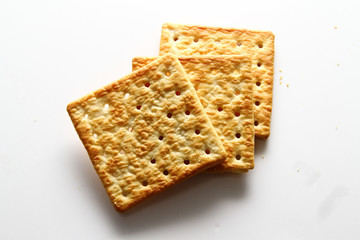 A cracker is a baked food typically made from flour. Flavorings or seasonings, such as salt, herbs, seeds, and/or cheese, may be added to the dough or sprinkled on top before baking