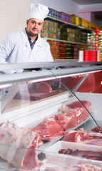Happy man near display with cooled meat
