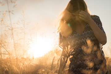 Girl in sunset light posing in field