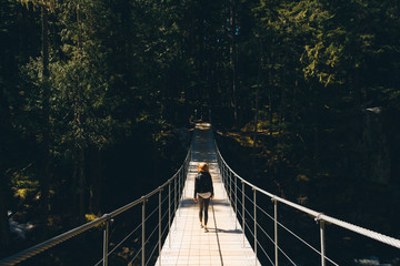 Woman walking on empty path through green forest