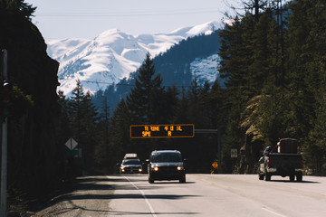 Obraz premium Highway with cars and snowy mountains in the background