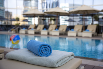 towel rolled up ready for guests at a swimming pool in an early morning
