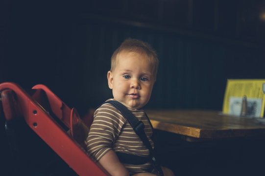 Baby on booster chair in cafe