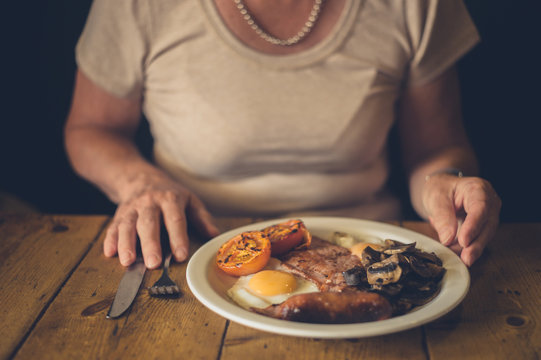 Senior woman eating english breakfast