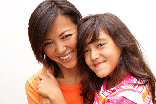 Loving Asian mother and daughter smiling.