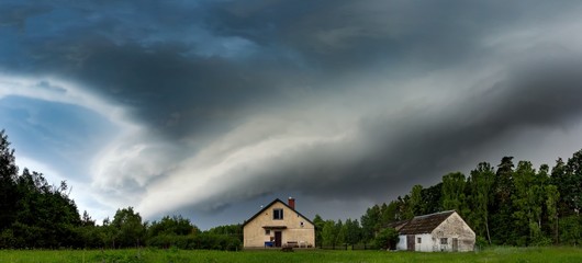 Scarry dark storm clouds over forest and house