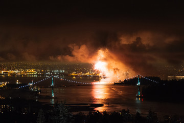 Naklejka na ściany i meble Fireworks at night above Vancouver with bridge and river