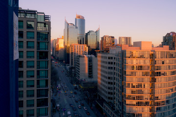 Fototapeta na wymiar Morning cityscape with sunrise illuminating top of building