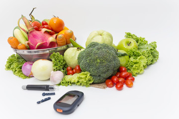 Glucose meter with  fresh  raw vegetables and fruits , desk of healthy organic vegetables, concept for healthy eating and diabetes.
