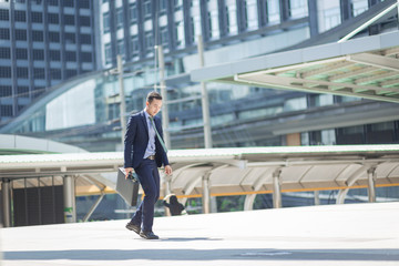 Businessman walking with bag in the city.