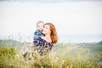 mother and son hugging in the grass