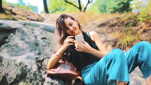 Young Female Student with a Mobile Phone in Central Park. New York US