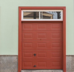 Rotes Tor einer Garage mit Fenster