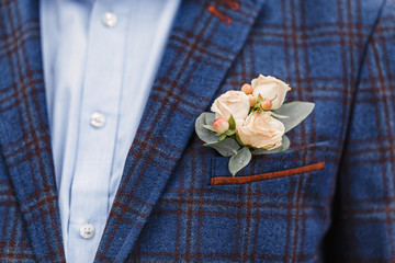 Groom with a wedding boutonniere in a checkered suit