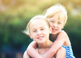 Two smiling little girls embracing