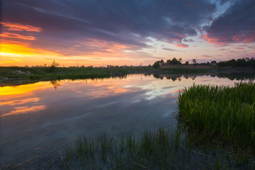 Fototapeta na wymiar Beautiful colorful sunset at countriside lake