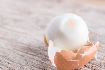 Peeled boiled egg on wood background