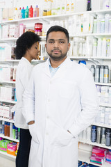 Fototapeta premium Chemist Standing With Hands In Pockets By Colleague