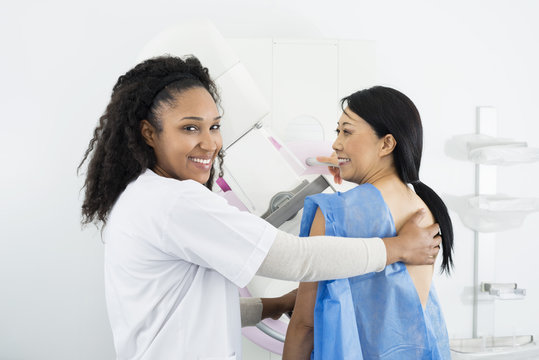 Female Doctor Assisting Woman Undergoing Mammogram X-ray Test