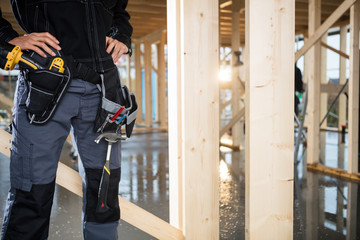 Midsection Of Carpenter Standing With Hands On Hips At Site