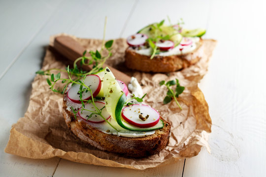 Sandwich with red radish, cucumber and fresh herbs and pepper.