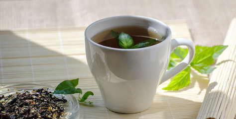 Cup of mint tea and a bunch of mint on the table