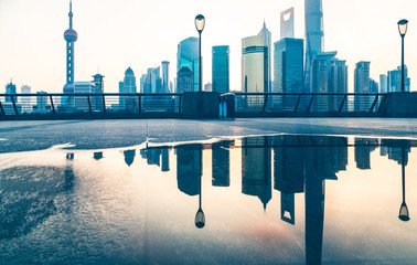 the bund skyline reflected in water puddle,shanghai,china.
