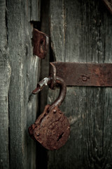 Old rusty opened lock without key. Vintage wooden door, close up concept photo