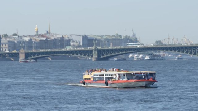 Tour boat moves on the Neva river on city background in the summer - St. Petersburg, Russia