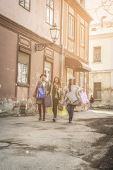 Three best friends walking on the street . Three best friends returning from shopping.