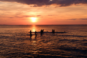 Fototapeta premium silhouettes of people having fun in sea sunset background