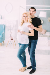 Pregnant girl with her husband smiling