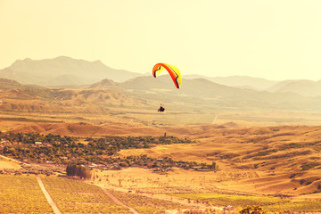 Paragliders fly over the valley.