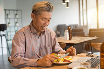 matured asian business male having breakfast