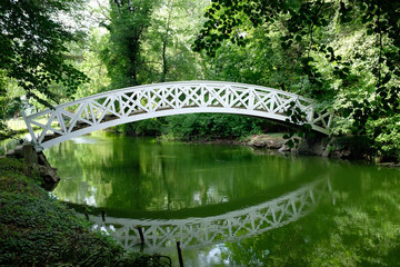 beautiful and romantic white bridge over a calm river