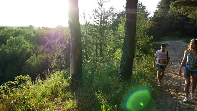 A girl walks through the woods and takes pictures of landscapes.