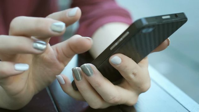 View of female's fingers touching screen on smartphone while browsing internet, steadycam shot
