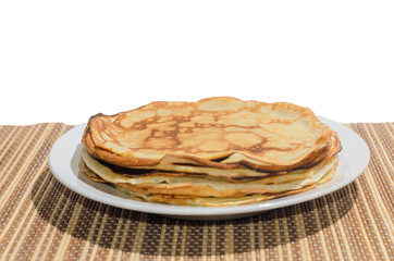 Russian traditional dishes - pancakes on a plate on a bamboo napkin