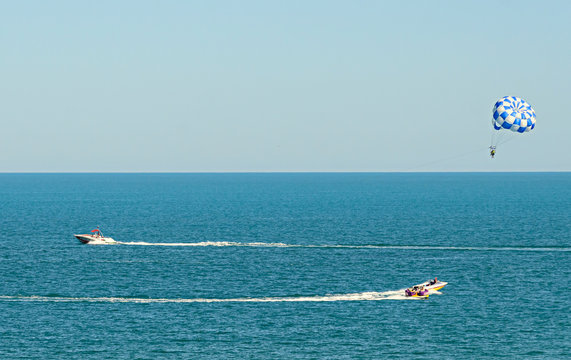 Blue parasail wing pulled by a boat in the sea water, Parasailing also known as parascending or parakiting