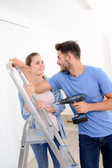 Obraz premium cheerful and happy young couple renovating and painting new home