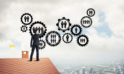 Businessman on house roof presenting teamwork and connection con