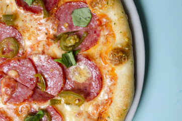 Pepperoni pizza on a white plate and blue background