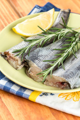 Fresh hake fish with rosemary and lemon on the plate