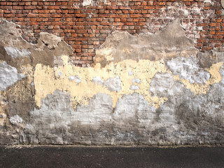 Old brick wall with peeling plaster, dark background for design