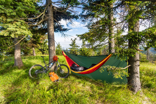 Camping with hammock  in summer woods on bike travel